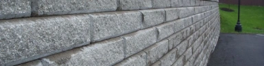 Sturdy Allan Block retaining wall, showcasing its modular design and natural stone appearance, ideal for landscaping and erosion control.